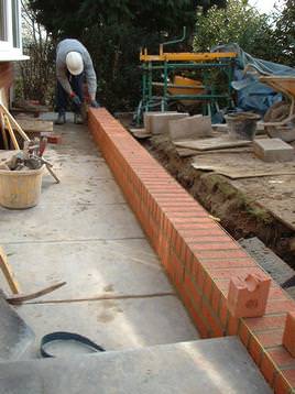 Apprentice bricklayer adding final touchs to 